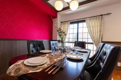 a dining room with a table and red wall at IROHA STAY HANEDA - Family-Friendly Home Stay near Haneda with Great Access to Tokyo & Yokohama in Tokyo