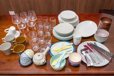 a wooden table topped with plates and wine glasses at IROHA STAY HANEDA - Family-Friendly Home Stay near Haneda with Great Access to Tokyo & Yokohama in Tokyo