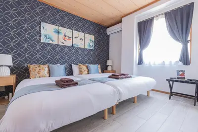 two beds in a bedroom with a wall at IROHA STAY HANEDA - Family-Friendly Home Stay near Haneda with Great Access to Tokyo & Yokohama in Tokyo