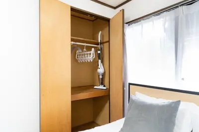 a bedroom with a bed and a wooden closet at \u30a8\u30b9\u30ab\u30eb\u690e\u540d\u753a in Tokyo