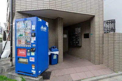a blue vending machine in front of a building at \u30a8\u30b9\u30ab\u30eb\u690e\u540d\u753a in Tokyo