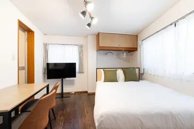 a hotel room with a bed and a desk and a television at \u30e1\u30be\u30f3\u7d4c\u5802 in Tokyo