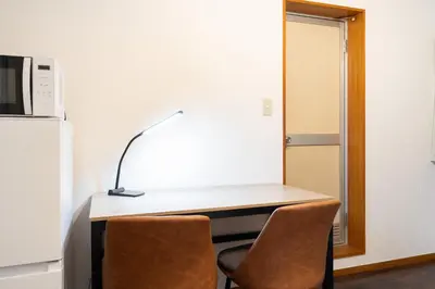 a desk with two chairs and a lamp on it at \u30e1\u30be\u30f3\u7d4c\u5802 in Tokyo
