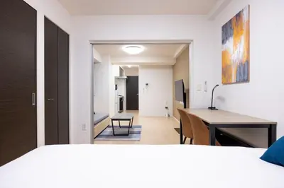 a room with a bed and a desk and a hallway at \u30f4\u30a3\u30e9\u4e21\u56fd in Tokyo