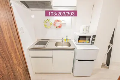 a small kitchen with a sink and a microwave at Shinjuku Downtown 1min walk to metro Cozy APT in Tokyo