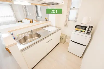 a kitchen with a sink and a microwave at Shinjuku Downtown 1min walk to metro Cozy APT in Tokyo