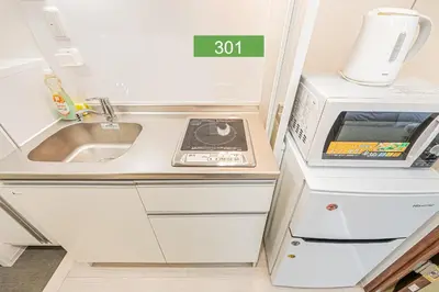 a small kitchen with a sink and a microwave at Shinjuku Downtown 1min walk to metro Cozy APT in Tokyo