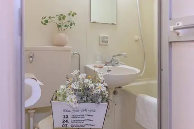 a bathroom with a sink and a toilet with flowers at 3mins from Nakano subway,Direct to Shinjuku,Up to 4 People in Tokyo