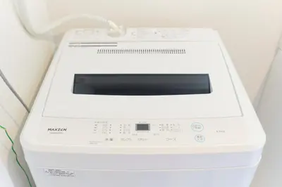 a white washing machine sitting on a wall at Metro Gate by Tranova in Tokyo
