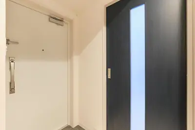 a black door in a room with a white wall at Metro Gate by Tranova in Tokyo