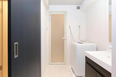 a bathroom with a door leading to a toilet at Metro Gate by Tranova in Tokyo