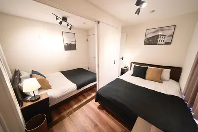 a bedroom with two beds and a mirror at TOMARIE Residential Suite Kita-Senju in Tokyo