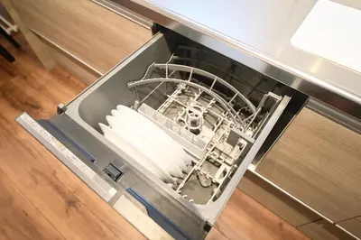 an empty dishwasher in a kitchen with its door open at TOMARIE Residential Suite Kita-Senju in Tokyo