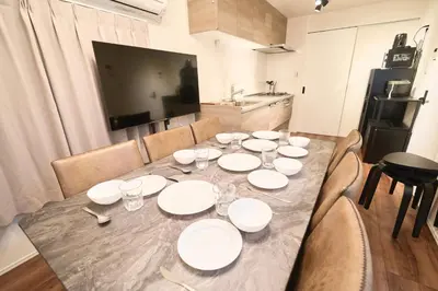 a table with white plates on it in a kitchen at TOMARIE Residential Suite Kita-Senju in Tokyo