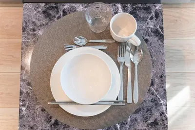 a table with a plate and silverware on a table at Sangenjaya Modern Stay in Tokyo