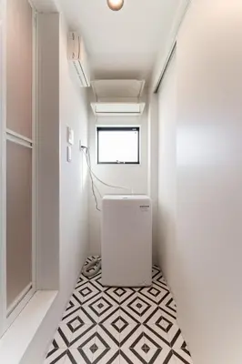 a hallway with a white room with a black and white floor at Sangenjaya Modern Stay in Tokyo
