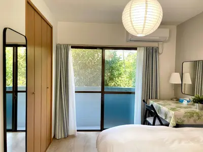 a bedroom with a bed and a table and a window at \u65b0\u5bbf\u4e00\u7ad95\u5206\u949f-201-\u9910\u9986\u8d2d\u7269\u8857-\u5b89\u9759\u54c1\u8d28\u516c\u5bd3-\u76f4\u8fbe\u7687\u5c45\u79cb\u53f6\u539f in Tokyo
