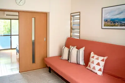 a room with a red couch with pillows on it at \u65b0\u5bbf\u4e00\u7ad95\u5206\u949f-201-\u9910\u9986\u8d2d\u7269\u8857-\u5b89\u9759\u54c1\u8d28\u516c\u5bd3-\u76f4\u8fbe\u7687\u5c45\u79cb\u53f6\u539f in Tokyo