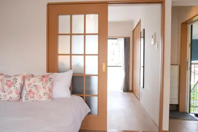 a bedroom with a white bed and a glass door at \u65b0\u5bbf\u4e00\u7ad95\u5206\u949f-201-\u9910\u9986\u8d2d\u7269\u8857-\u5b89\u9759\u54c1\u8d28\u516c\u5bd3-\u76f4\u8fbe\u7687\u5c45\u79cb\u53f6\u539f in Tokyo