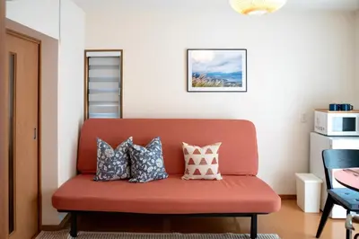 a red couch with pillows on it in a room at \u65b0\u5bbf\u4e00\u7ad95\u5206\u949f-201-\u9910\u9986\u8d2d\u7269\u8857-\u5b89\u9759\u54c1\u8d28\u516c\u5bd3-\u76f4\u8fbe\u7687\u5c45\u79cb\u53f6\u539f in Tokyo