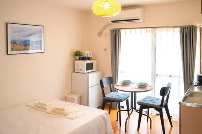 a small room with a table and chairs and a kitchen at \u65b0\u5bbf\u4e00\u7ad95\u5206\u949f-201-\u9910\u9986\u8d2d\u7269\u8857-\u5b89\u9759\u54c1\u8d28\u516c\u5bd3-\u76f4\u8fbe\u7687\u5c45\u79cb\u53f6\u539f in Tokyo