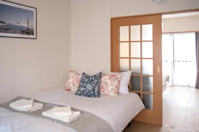 a room with a bed with pillows and a window at \u65b0\u5bbf\u4e00\u7ad95\u5206\u949f-201-\u9910\u9986\u8d2d\u7269\u8857-\u5b89\u9759\u54c1\u8d28\u516c\u5bd3-\u76f4\u8fbe\u7687\u5c45\u79cb\u53f6\u539f in Tokyo