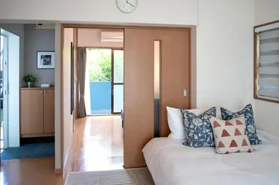 a bedroom with a bed and a clock on the wall at \u65b0\u5bbf\u4e00\u7ad95\u5206\u949f-201-\u9910\u9986\u8d2d\u7269\u8857-\u5b89\u9759\u54c1\u8d28\u516c\u5bd3-\u76f4\u8fbe\u7687\u5c45\u79cb\u53f6\u539f in Tokyo
