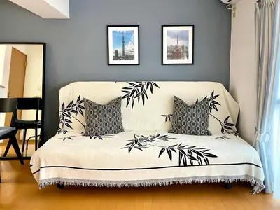 a bedroom with a white couch with black leaves on it at \u65b0\u5bbf\u4e00\u7ad95\u5206\u949f-303-\u9910\u9986\u8d2d\u7269\u8857-\u5b89\u9759\u54c1\u8d28\u516c\u5bd3-\u76f4\u8fbe\u7687\u5c45\u79cb\u53f6\u539f in Tokyo
