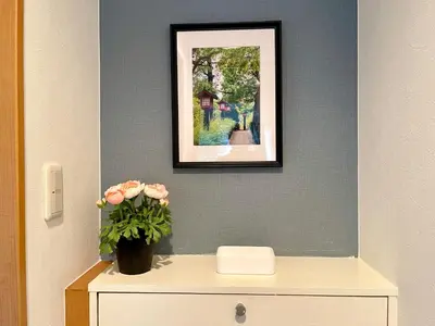 a picture on a wall with a vase of flowers on a dresser at \u65b0\u5bbf\u4e00\u7ad95\u5206\u949f-303-\u9910\u9986\u8d2d\u7269\u8857-\u5b89\u9759\u54c1\u8d28\u516c\u5bd3-\u76f4\u8fbe\u7687\u5c45\u79cb\u53f6\u539f in Tokyo