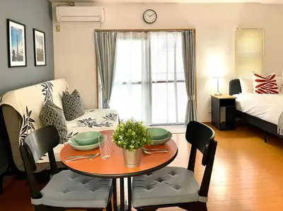a living room with a table and a bedroom at \u65b0\u5bbf\u4e00\u7ad95\u5206\u949f-303-\u9910\u9986\u8d2d\u7269\u8857-\u5b89\u9759\u54c1\u8d28\u516c\u5bd3-\u76f4\u8fbe\u7687\u5c45\u79cb\u53f6\u539f in Tokyo