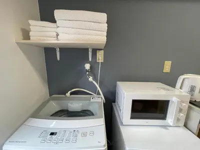 a kitchen with a microwave and a pile of towels at \u65b0\u5bbf\u4e00\u7ad95\u5206\u949f-303-\u9910\u9986\u8d2d\u7269\u8857-\u5b89\u9759\u54c1\u8d28\u516c\u5bd3-\u76f4\u8fbe\u7687\u5c45\u79cb\u53f6\u539f in Tokyo