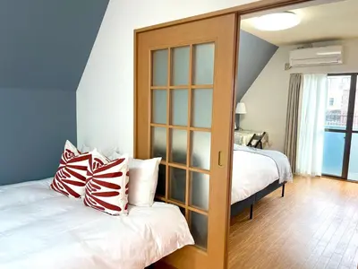 a bedroom with two beds and a large glass closet at \u65b0\u5bbf\u4e00\u7ad95\u5206\u949f-304-\u9910\u9986\u8d2d\u7269\u8857-\u5b89\u9759\u54c1\u8d28\u516c\u5bd3-\u76f4\u8fbe\u7687\u5c45\u79cb\u53f6\u539f in Tokyo