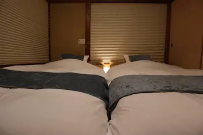 two beds sitting next to each other in a bedroom at \u65c5\u306e\u5bbfhitotoki in Tokyo