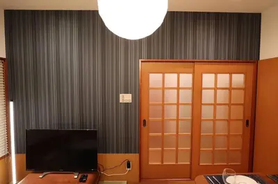 a living room with a television and a door at \u65c5\u306e\u5bbfhitotoki in Tokyo