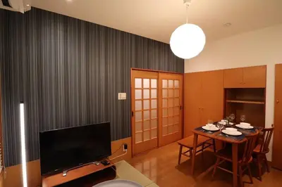 a living room with a table and a television at \u65c5\u306e\u5bbfhitotoki in Tokyo