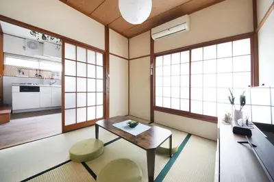 a room with a table and two chairs and windows at Machiya \u4eac Asakusa in Tokyo