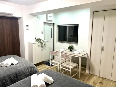 a hotel room with two beds and a table in it at Ikebukuro Area R2 NishiikeApartment 5F No Elevator in Tokyo