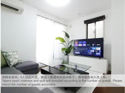 a living room with a glass table and a tv at New Open\u6771\u65b0\u5bbf \u6238\u5efa in Tokyo