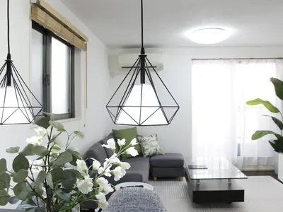 a living room with a gray couch and two hanging lights at New Open\u6771\u65b0\u5bbf \u6238\u5efa in Tokyo
