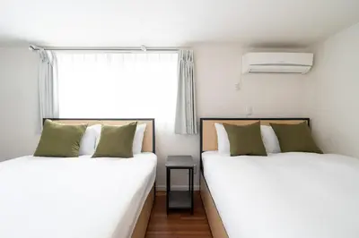 two beds sitting next to a window in a room at \u6a2a\u5ddd\u30cf\u30a6\u30b9 in Tokyo