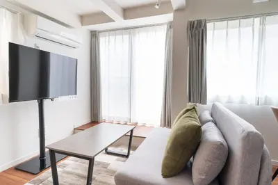 a living room with a couch and a tv at \u6a2a\u5ddd\u30cf\u30a6\u30b9 in Tokyo