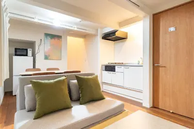 a living room with a couch and a kitchen at \u6a2a\u5ddd\u30cf\u30a6\u30b9 in Tokyo