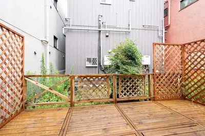 a wooden deck with a gate and a building at \u6a2a\u5ddd\u30cf\u30a6\u30b9 in Tokyo