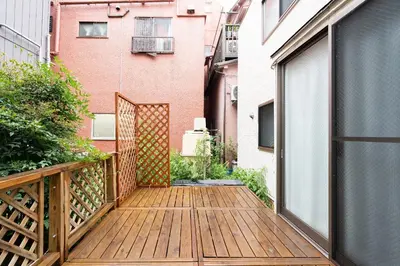 a balcony with a wooden deck and a building at \u6a2a\u5ddd\u30cf\u30a6\u30b9 in Tokyo