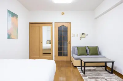 a room with a bed and a couch and a table at \u5357\u9752\u5c71227\u30d3\u30eb in Tokyo
