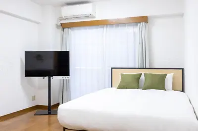 a bedroom with a large bed and a flat screen tv at \u5357\u9752\u5c71227\u30d3\u30eb in Tokyo