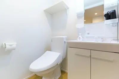 a white bathroom with a toilet and a sink at Maison Asch Ikebukuro by Tranova in Tokyo