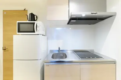 a small kitchen with a sink and a microwave at Maison Asch Ikebukuro by Tranova in Tokyo