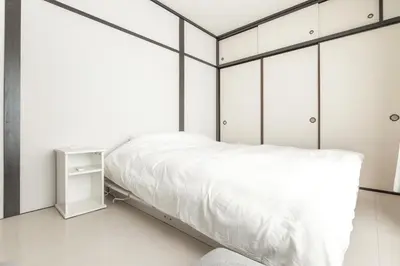 a bedroom with a bed and white cabinets at Waseda BNB Shinjuku in Tokyo