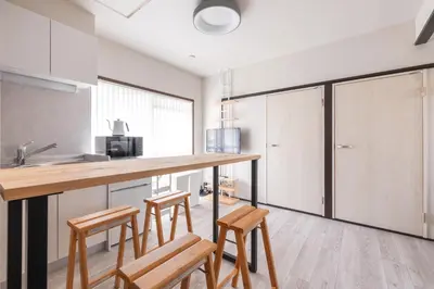 a kitchen with wooden counter stools and a counter top at Waseda BNB Shinjuku in Tokyo